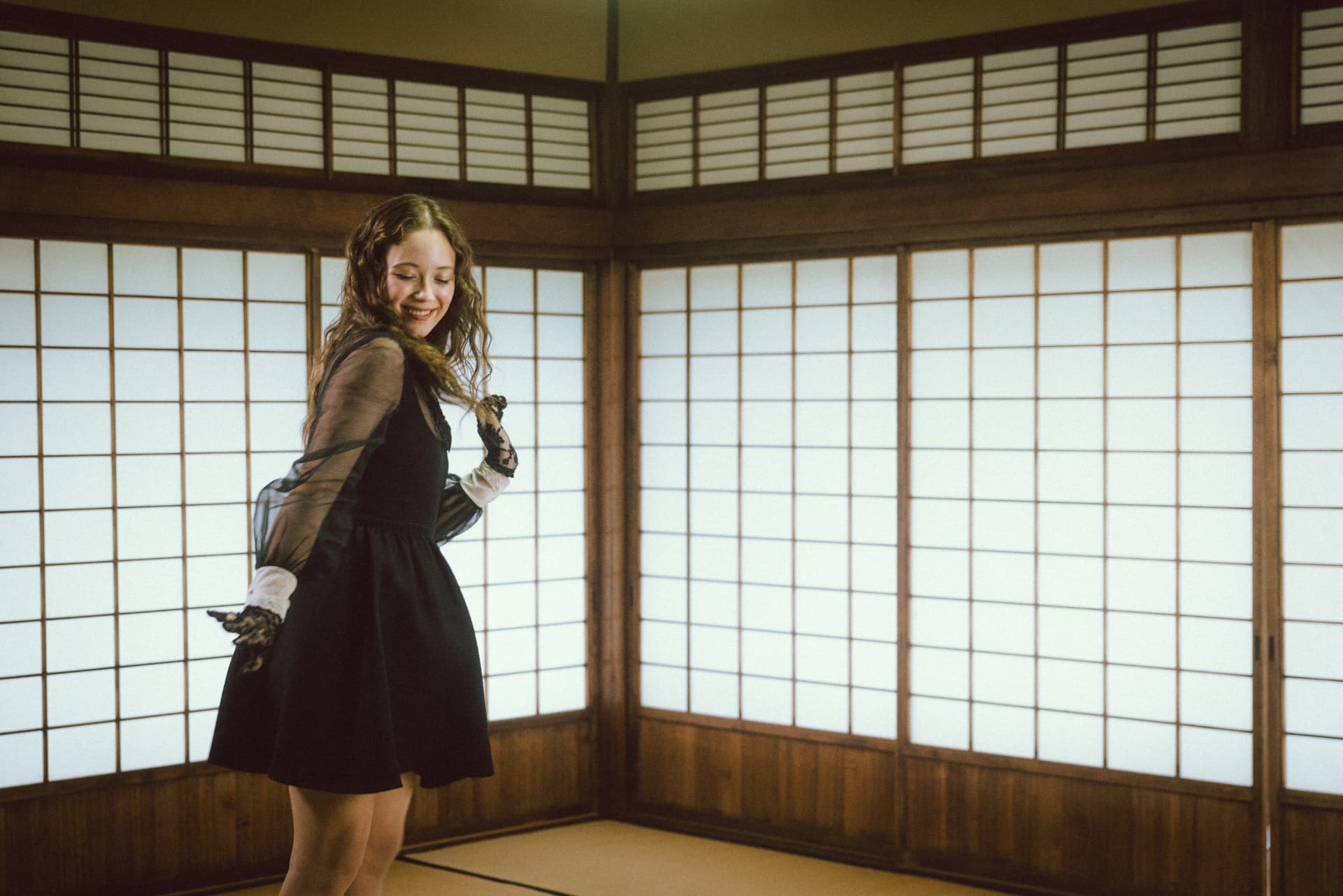Laufey smiling in a tatami room with shoji screens